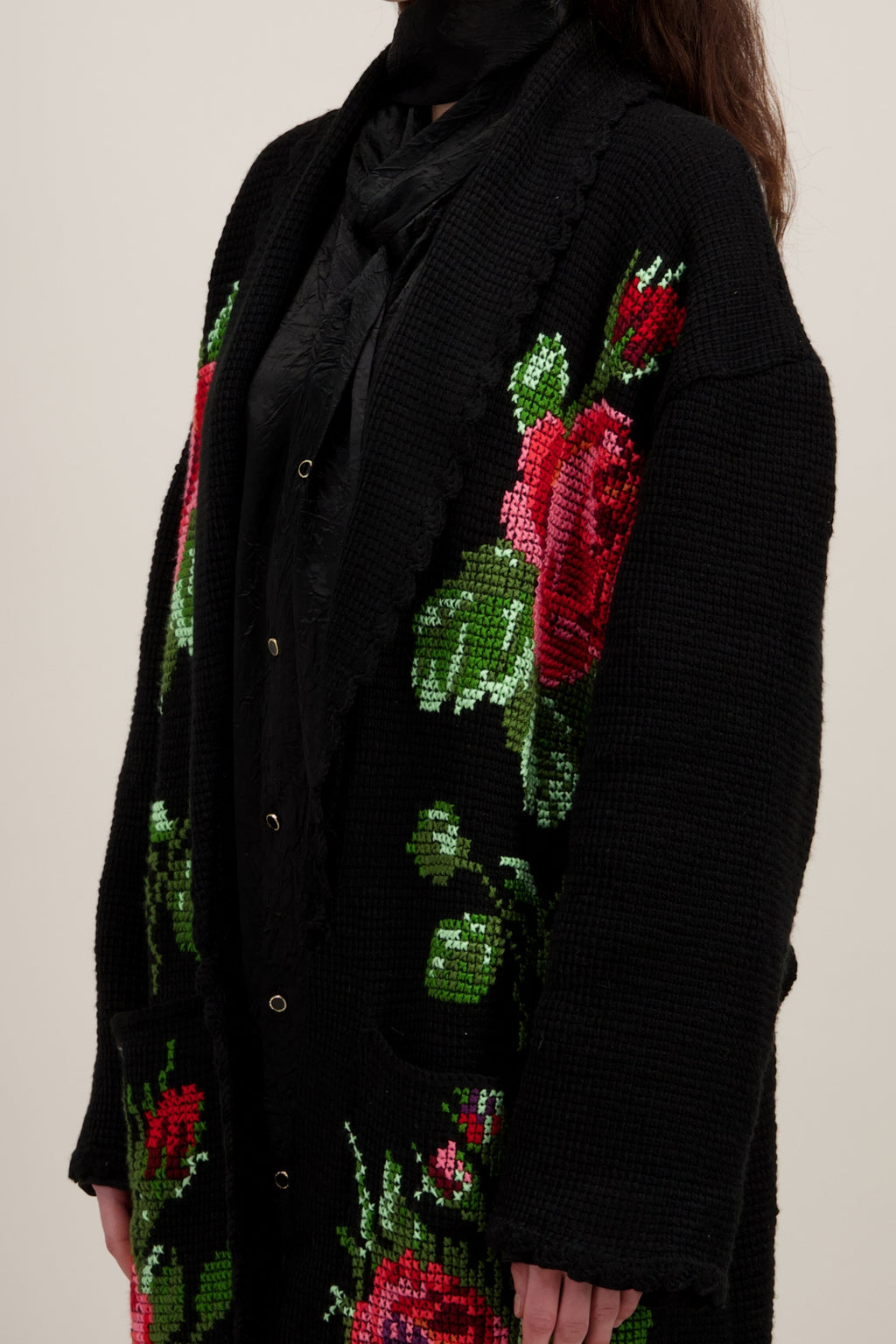 Manteau long en crochet, noir et motifs floraux. Vu en détail