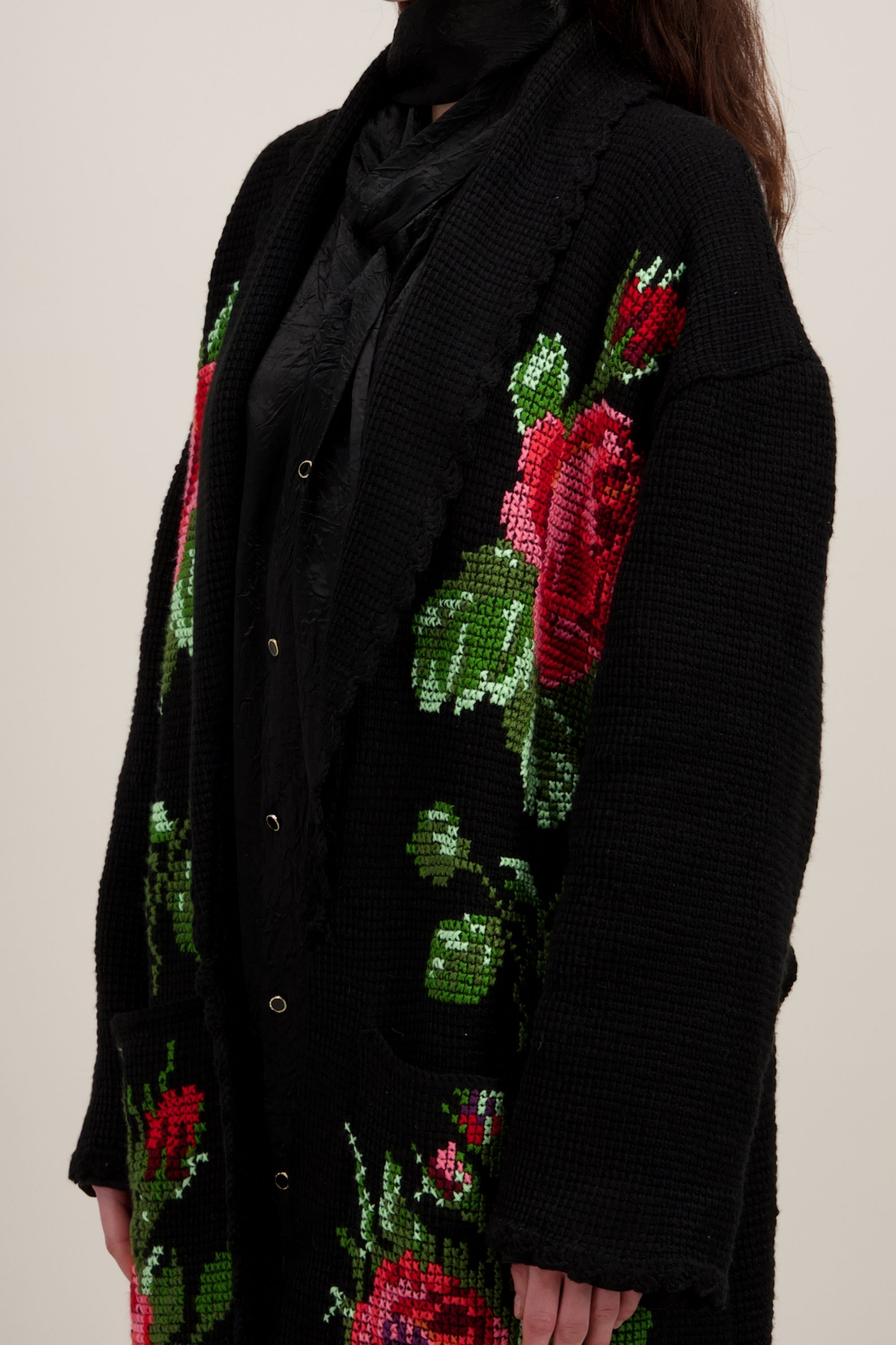 Manteau long en crochet, noir et motifs floraux. Vu en détail