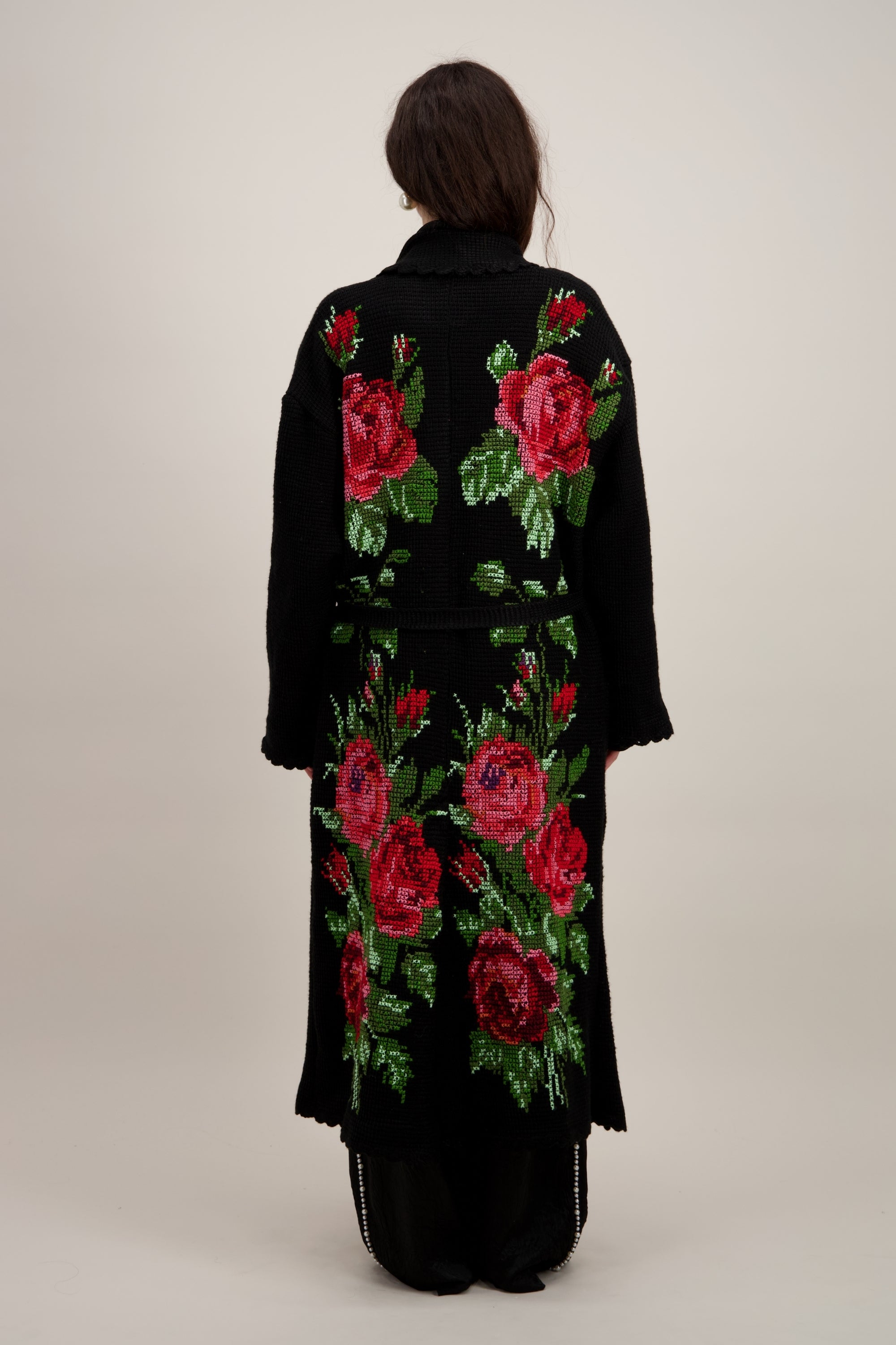 Manteau long en crochet, noir et motifs floraux. Vu de dos