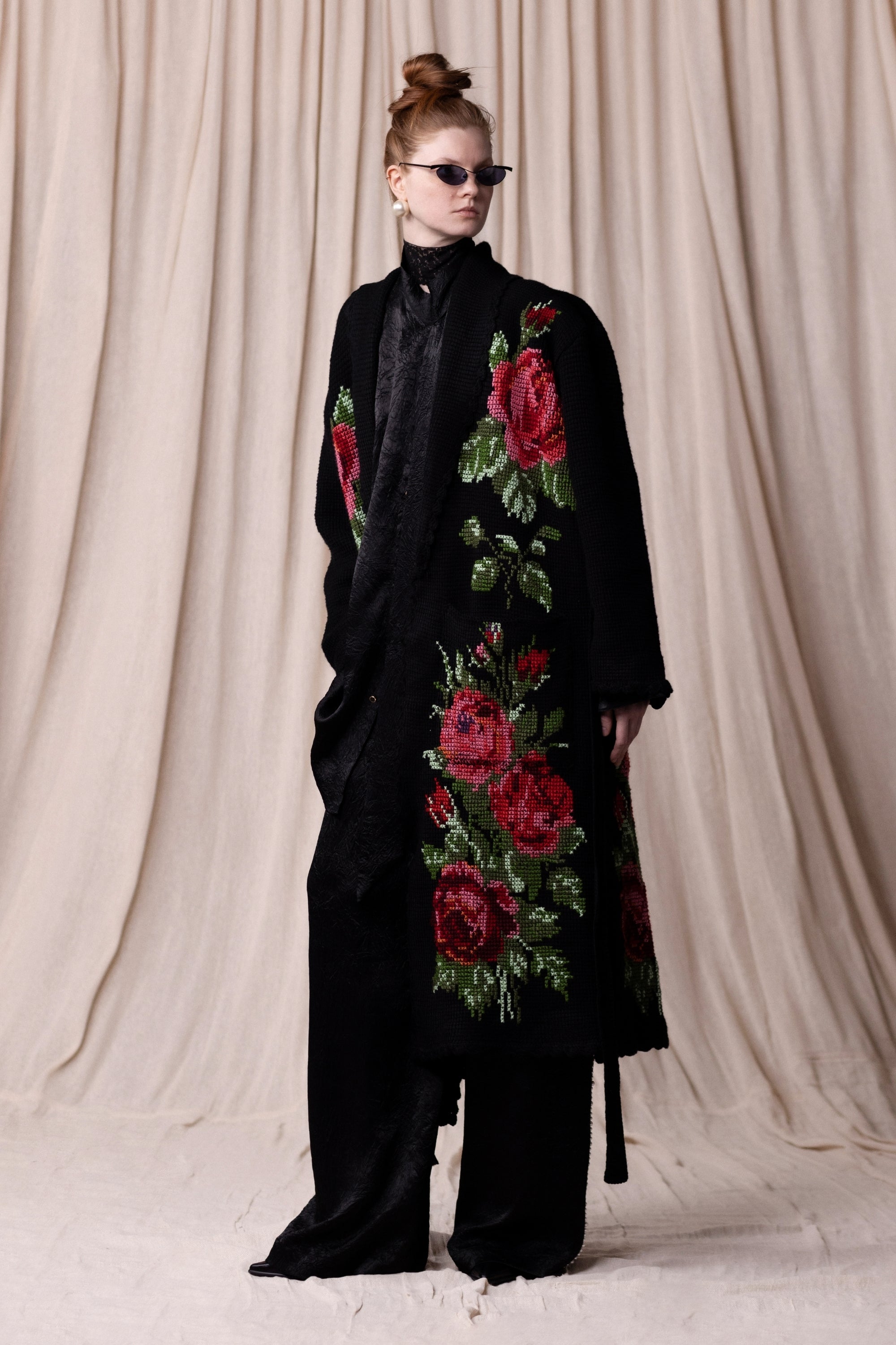 Manteau long en crochet, noir et motifs floraux. Vu en total look