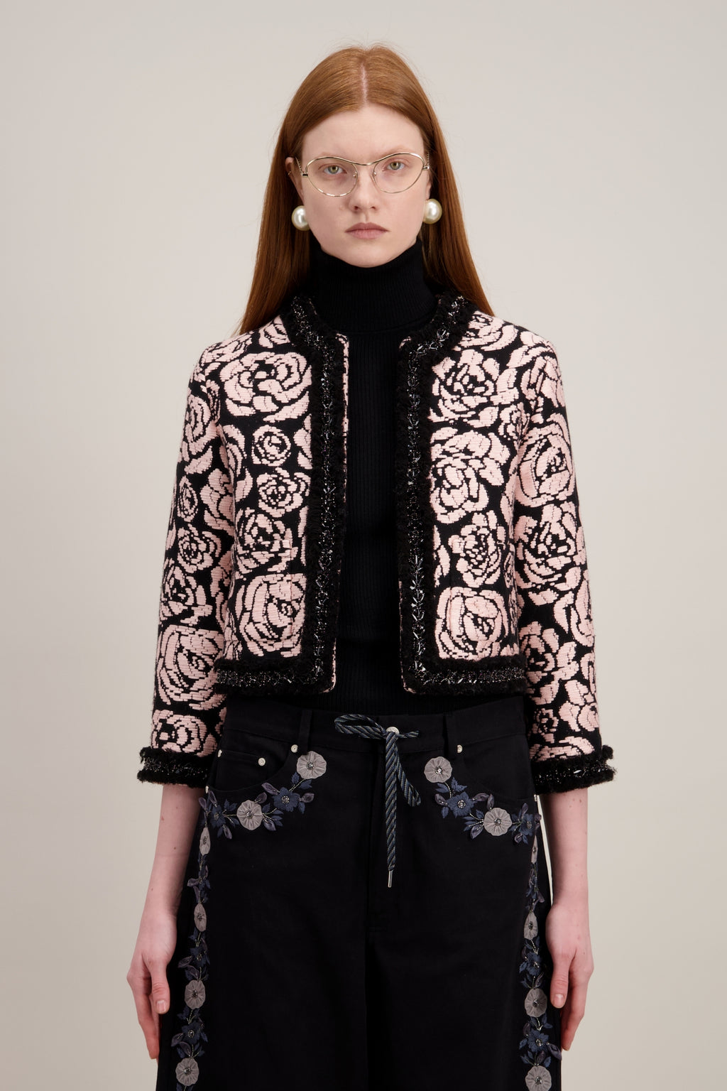 Veste courte en jacquard, noire et sans col. Vu en détail