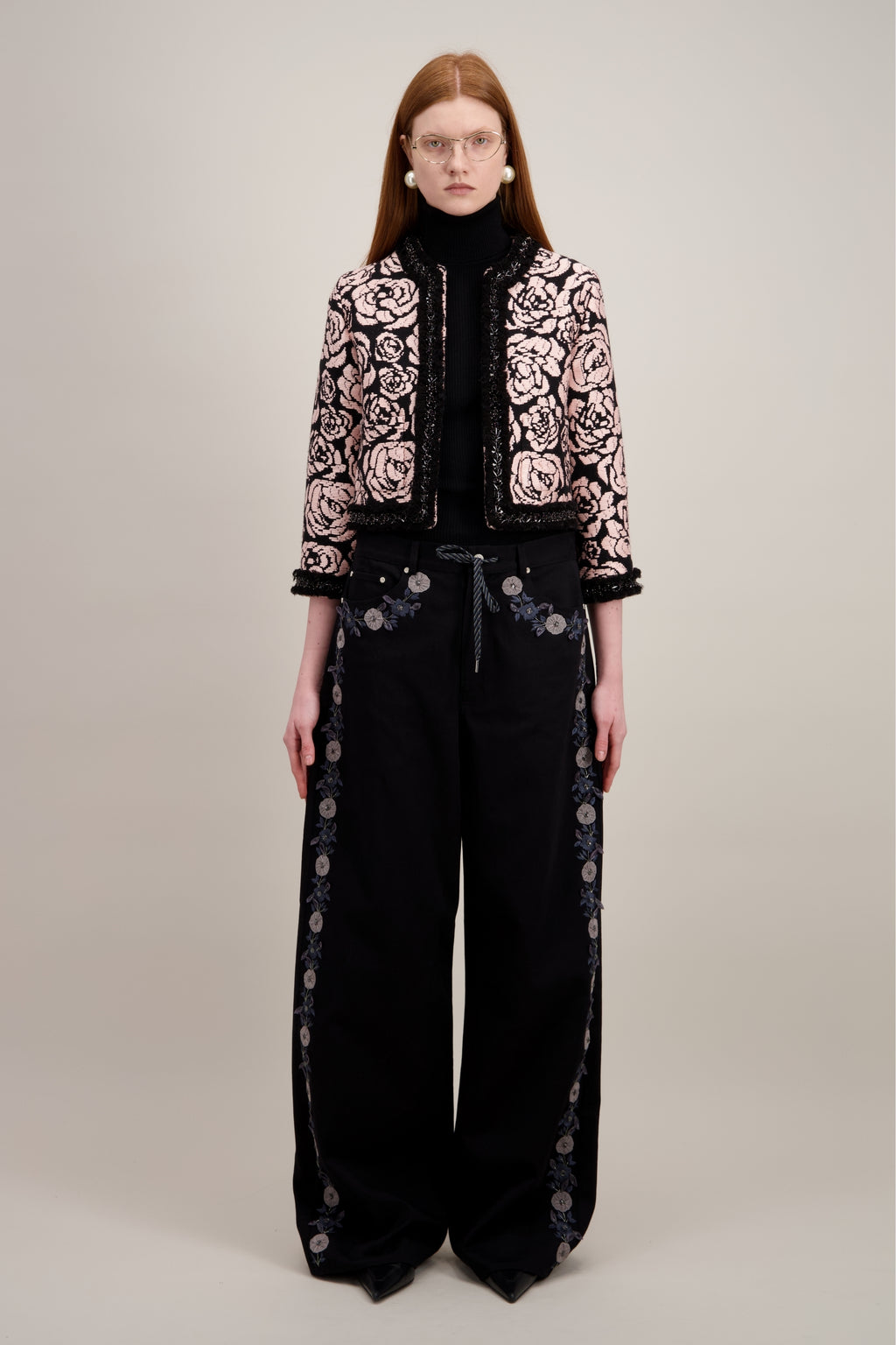 Veste courte en jacquard, noire et sans col. Vu en entier