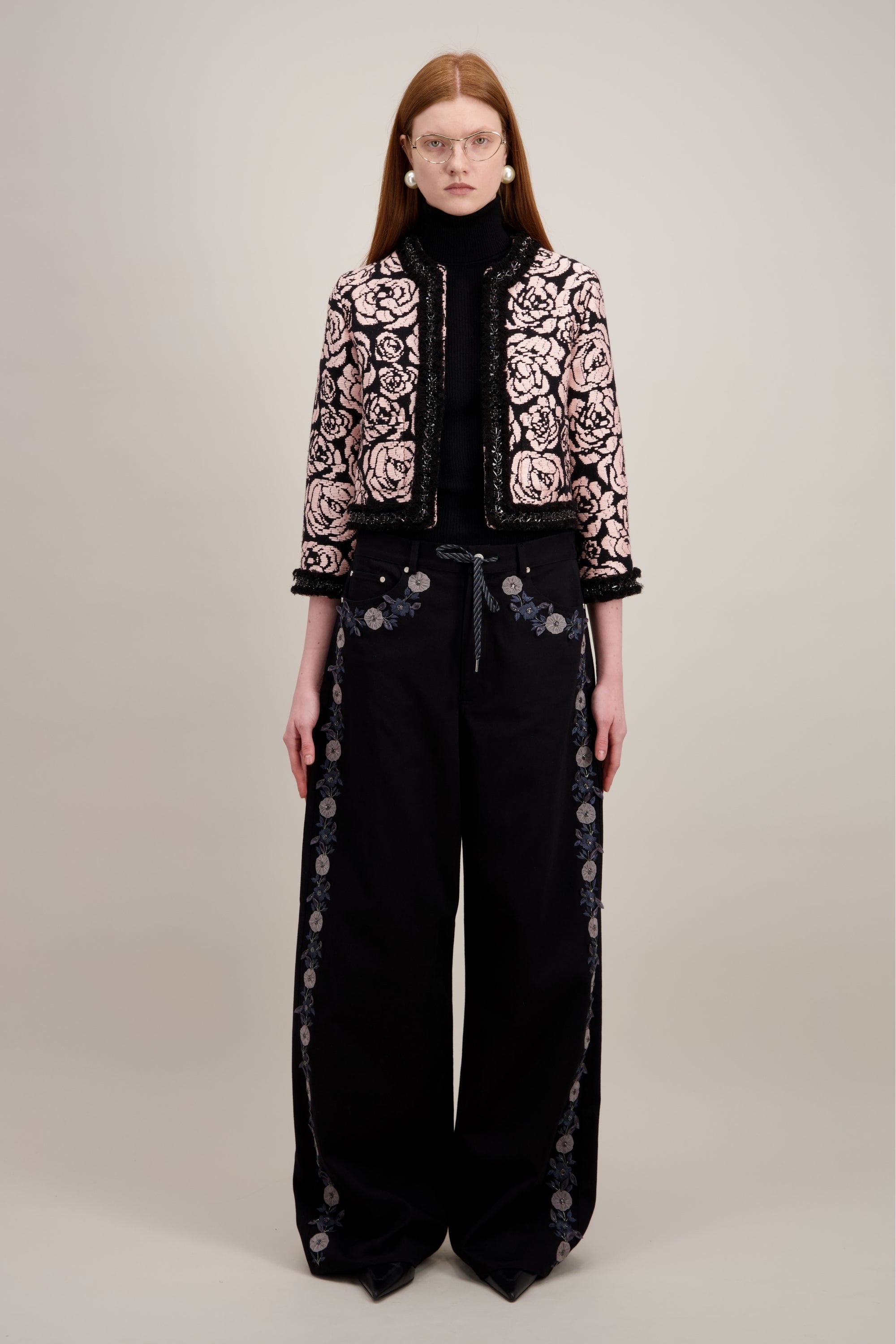 Veste courte en jacquard, noire et sans col. Vu en entier