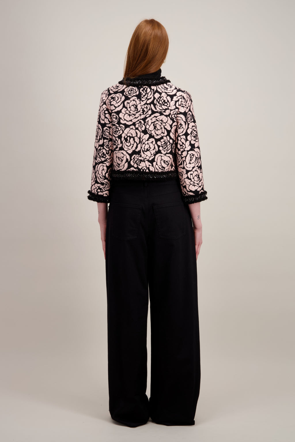 Veste courte en jacquard, noire et sans col. Vu de dos