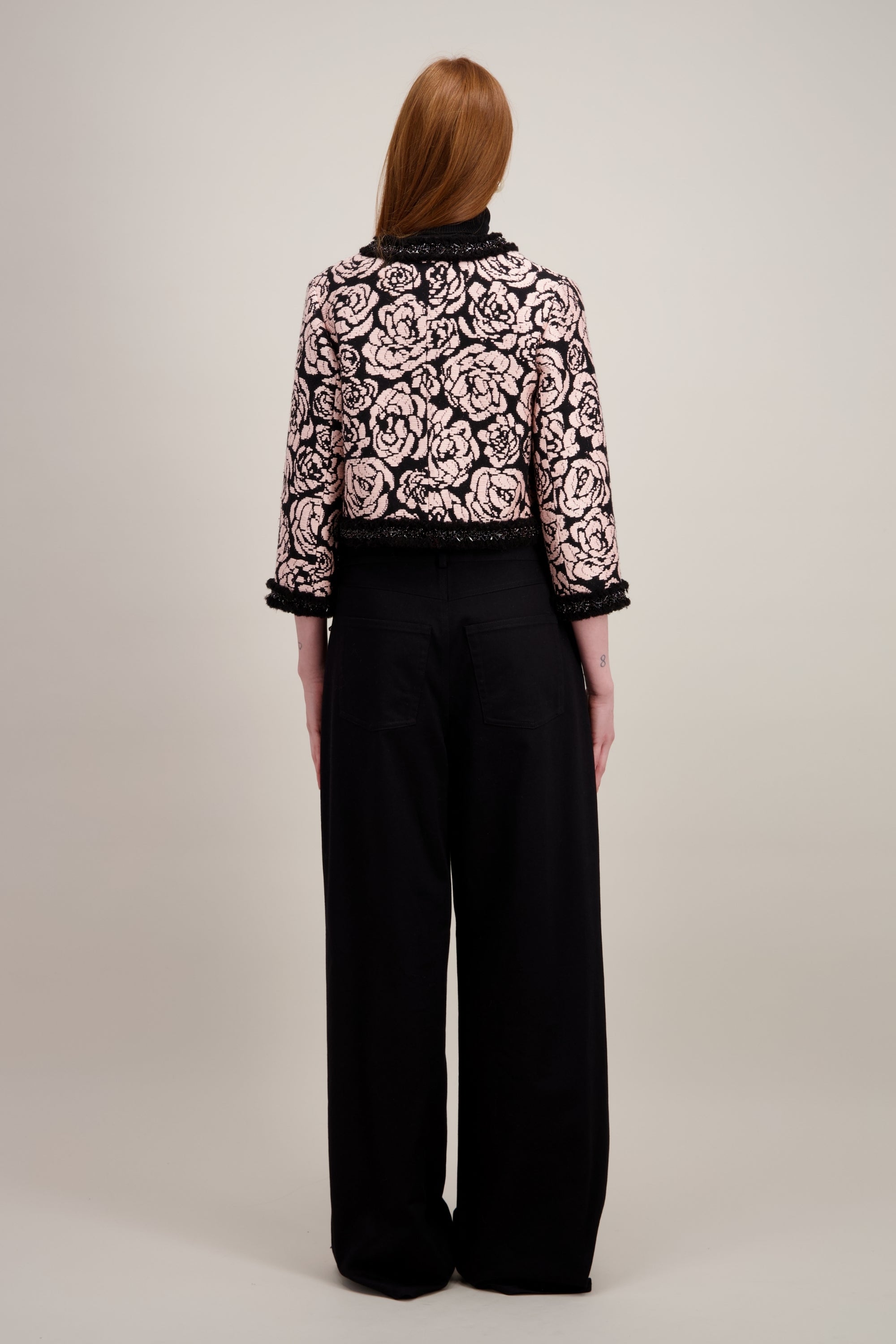 Veste courte en jacquard, noire et sans col. Vu de dos