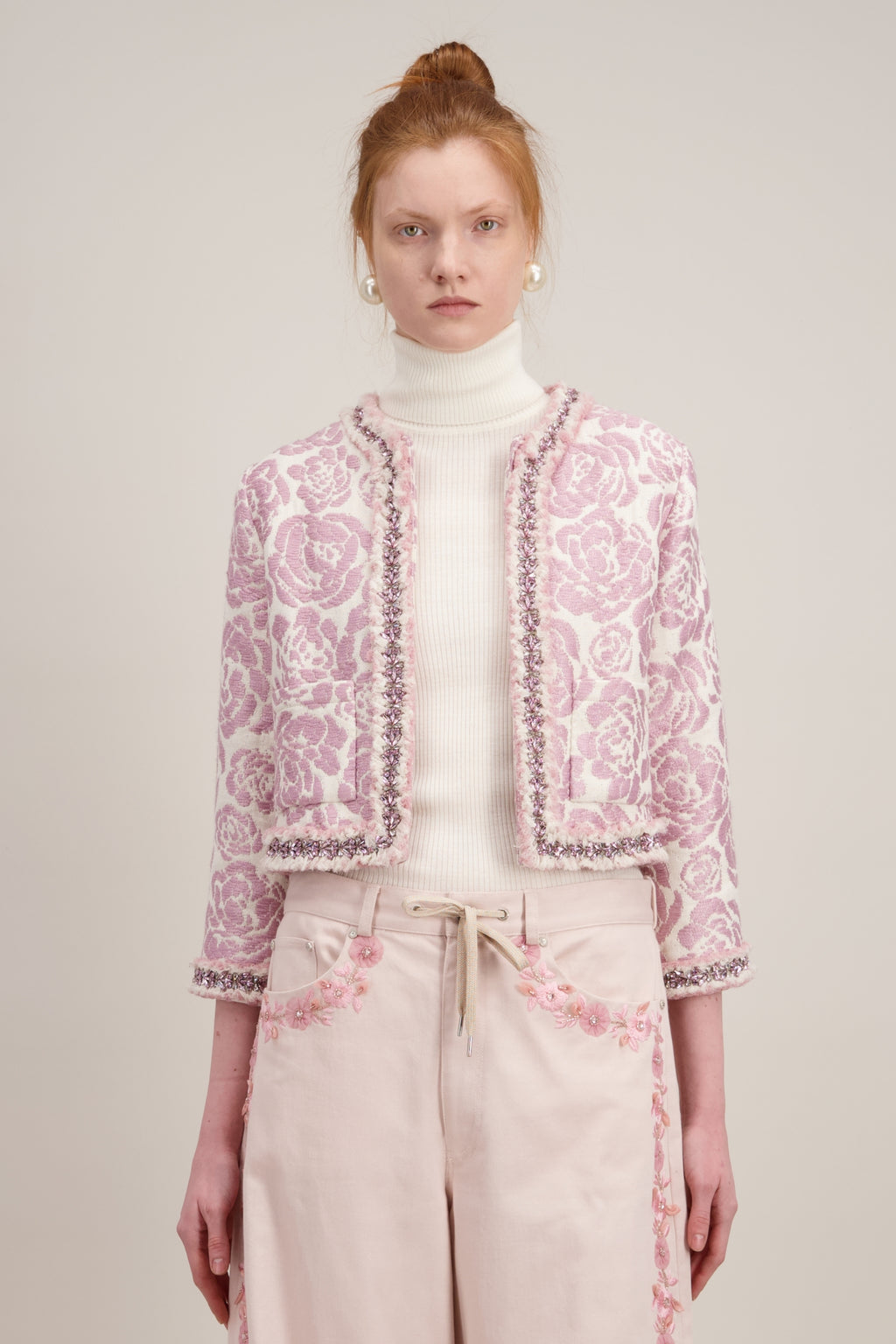 Veste courte en jacquard, rose et sans col. Vu en détail
