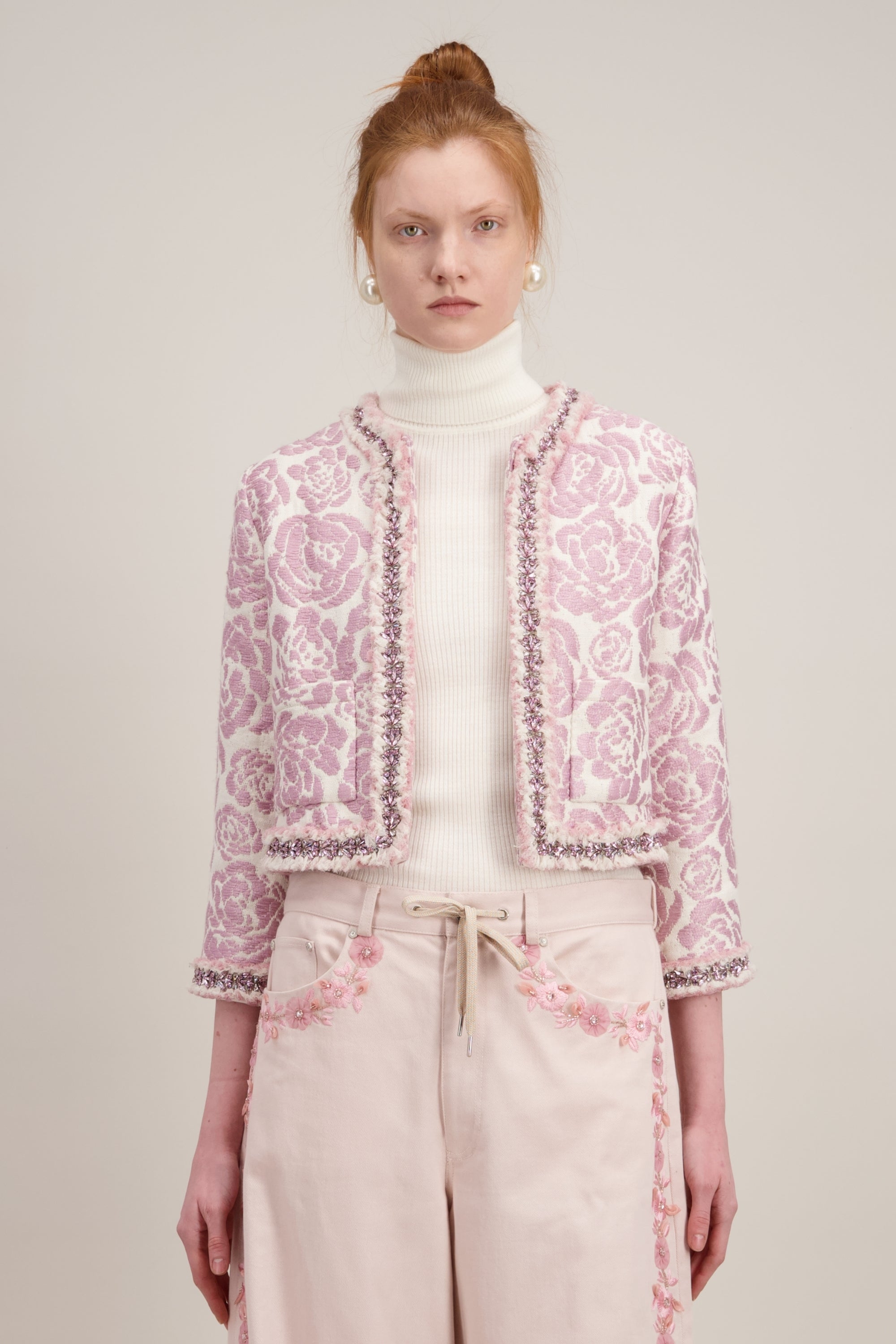 Veste courte en jacquard, rose et sans col. Vu en détail
