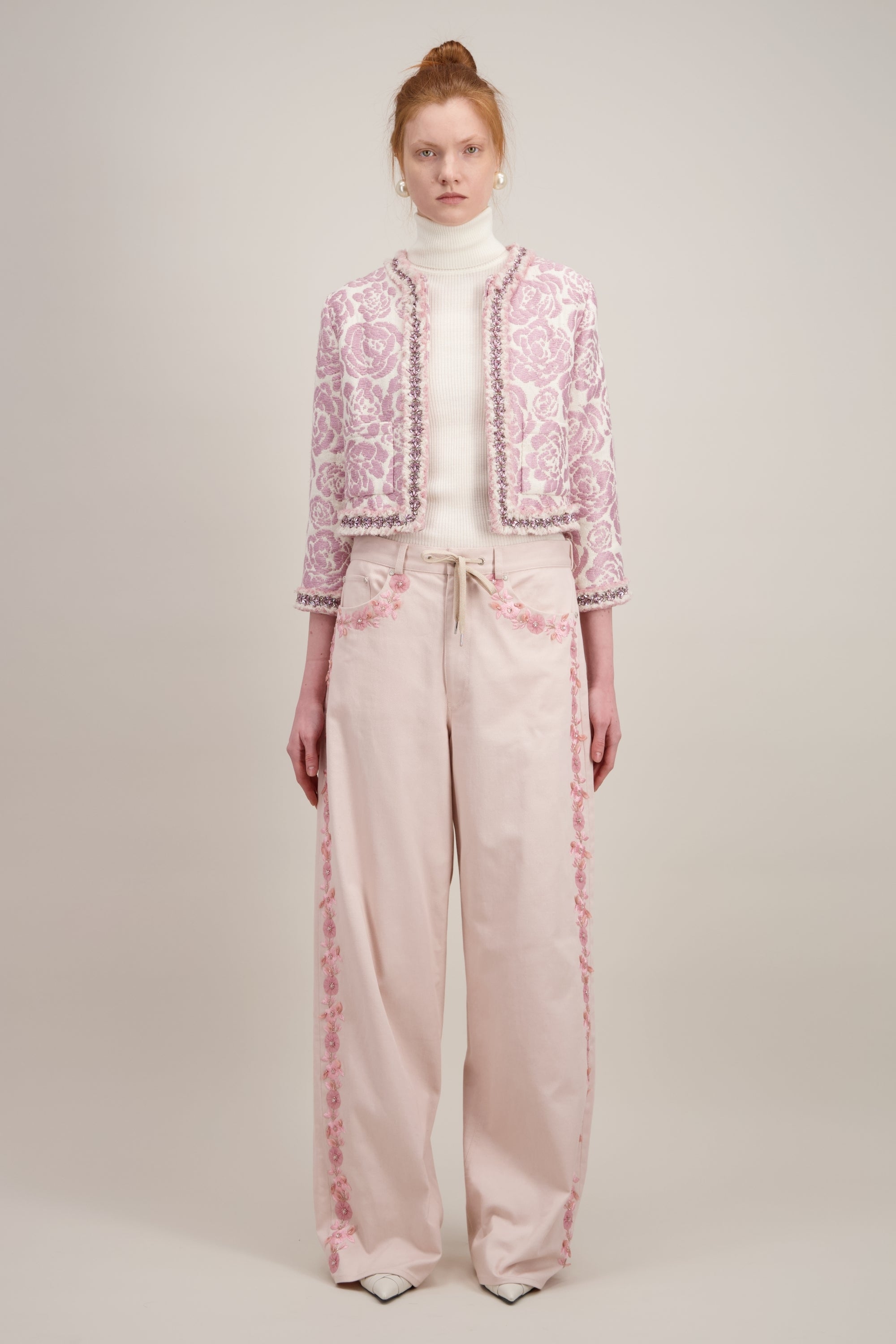 Veste courte en jacquard, rose et sans col. Vu en entier