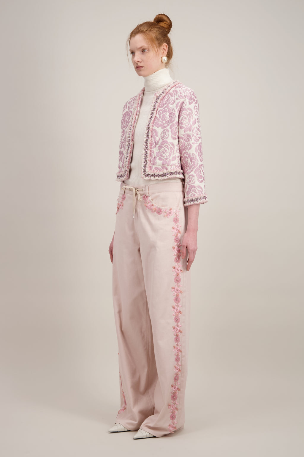 Veste courte en jacquard, rose et sans col. Vu de trois quarts