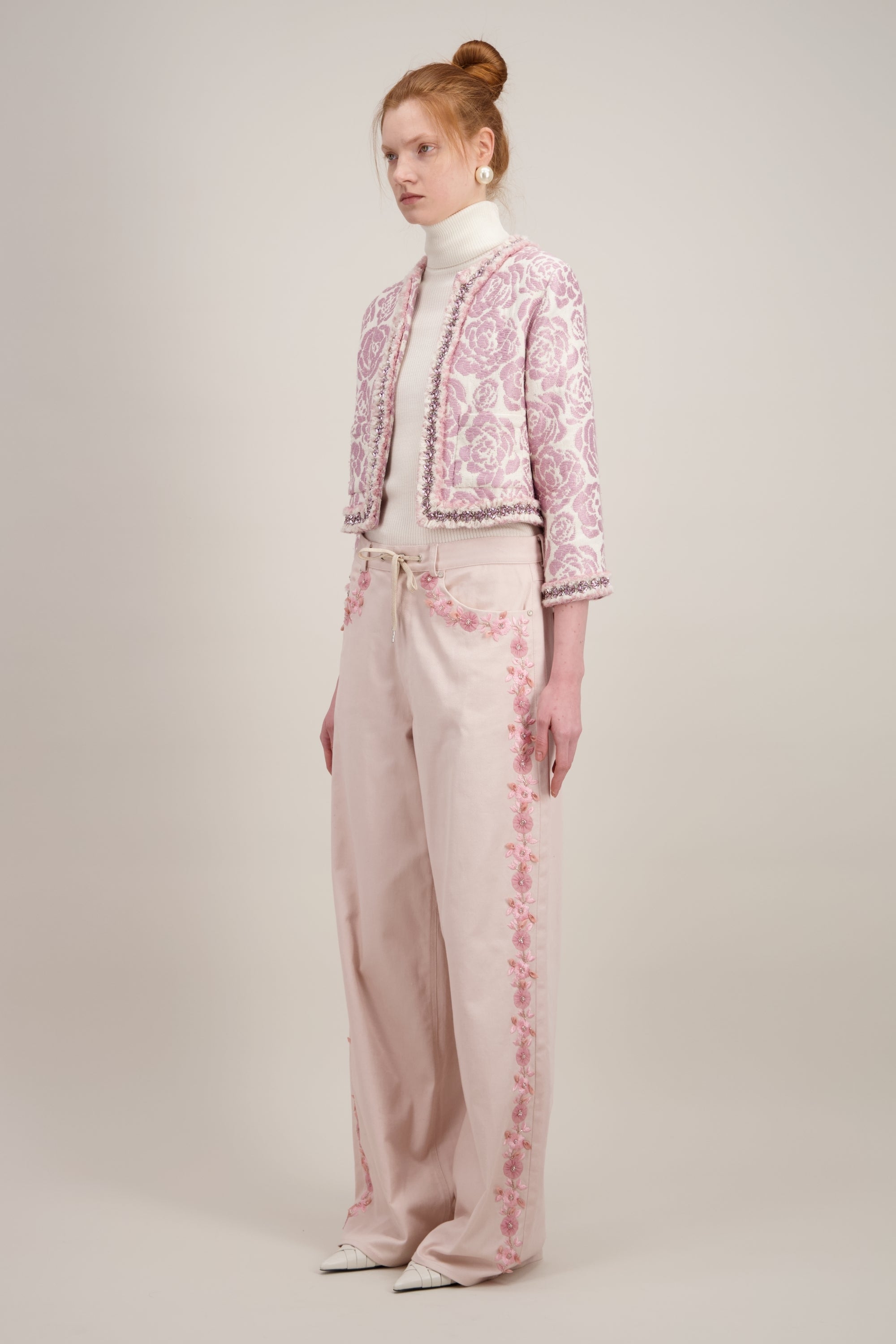 Veste courte en jacquard, rose et sans col. Vu de trois quarts